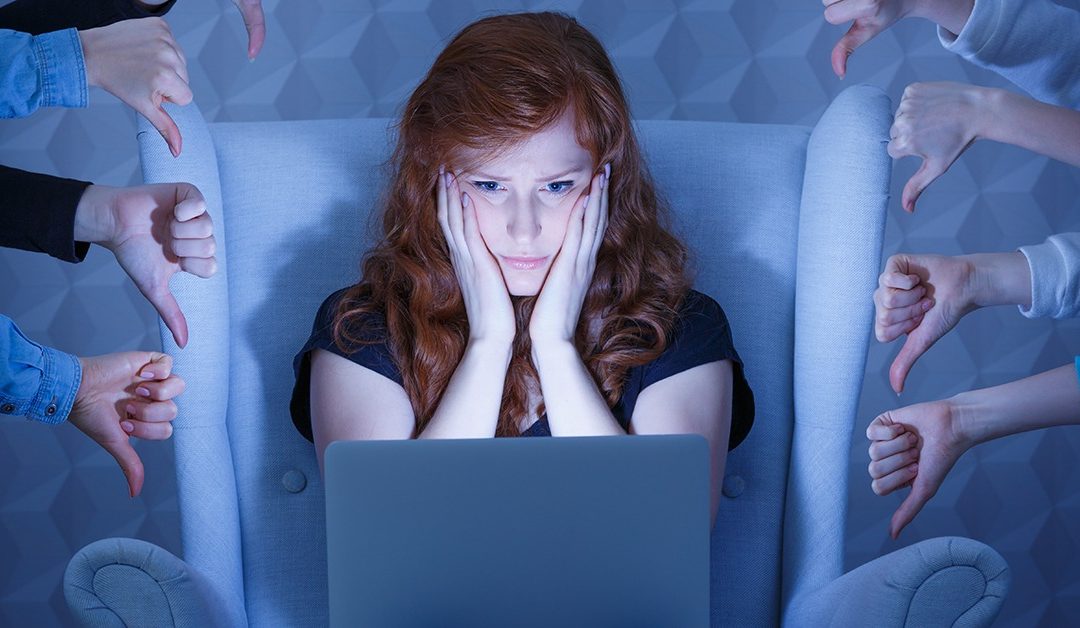 Worried young woman having negative comments on her website